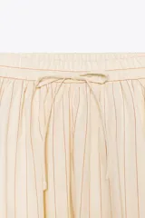 Falda midi de Zara Woman Collection confeccionada en hilatura de algodón color crudo con finas rayas verticales marrones. Tiene tiro medio, cintura elástica ajustable con cordones y bajo evasé.
