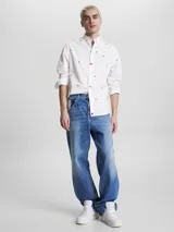 Camisa blanca de popelina de puro algodón con estampado de banderas náuticas y logos de Tommy Jeans bordados. Corte clásico, cuello abotonado, puños con botón y bajo redondeado.