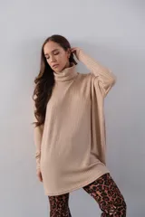 Polerón color beige de punto morley, con cuello alto y mangas largas.
