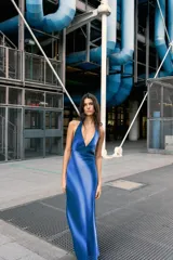 Vestido largo de seda azul con estampado degradado que simula ondas o nubes. Presenta escote halter con tiras finas ajustables y aberturas laterales en la cintura.