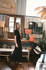 Vestido largo de tejido acanalado, con diseño bicolor vertical: mitad negro y mitad beige claro. Tiene mangas cortas y escote en V.