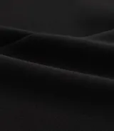 Bermuda de crepé color rojo, con pliegues frontales y botones decorativos en los bolsillos laterales.