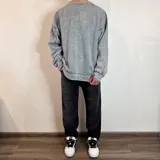 Buzo celeste con efecto gastado, corte oversize, cuello redondo y puños y ruedo acanalados.