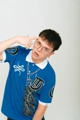 Chomba azul de piqué con cuello blanco, corte regular, manga corta con puños blancos, estampado con logo en la manga y bordado en el pecho.