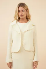 Chaqueta color crudo de lana fina sin teñir, de corte recto con cuello solapa y mangas 3/4.