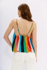 Top de viscosa con estampado a rayas multicolores, calce holgado y elástico en la espalda. Presenta breteles trenzados en distintos tonos.