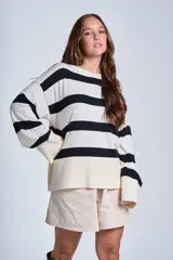 Sweater Bremer con cuello redondo y mangas largas ligeramente amplias. Diseño a rayas horizontales en color crudo y negro.