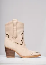 Bota corta de gamuza color manteca, estilo western, con apliques de tachas doradas y taco de madera.