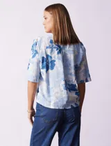 Blusa de lino estampada con flores azules, marca Hester & Orchard. Cuello a la base y abertura central con botones.