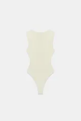 Body entallado color marrón oscuro con escote pronunciado en pico y manga sisa. Cierre en la parte inferior con botones a presión.