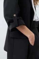 Blazer color crudo de corte recto, con cuello solapa, mangas 3/4 con botón y bolsillos frontales.