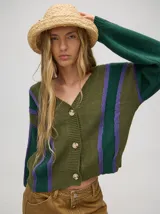 Cardigan corto de punto color verde oliva con rayas verticales en verde oscuro y lila. Tiene escote en V, mangas largas y botones al frente.