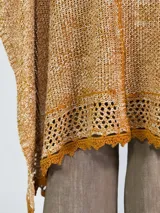 Ruana color crudo de tejido de punto calado con terminaciones en crochet.