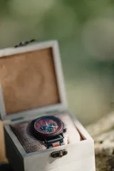 Reloj multifuncional para hombre, con caja de madera de sándalo rojo y acero inoxidable negro. La esfera es de madera de sándalo rojo con subdiales negros funcionales que ofrecen cronógrafo, indicador de 24 horas y fechador. La malla es de acero inoxidable negro con incrustaciones de madera de sándalo rojo.