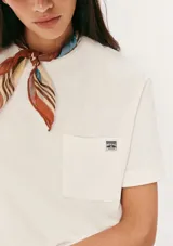 Camiseta manga corta color marrón con bolsillo en el pecho y parche con logo.