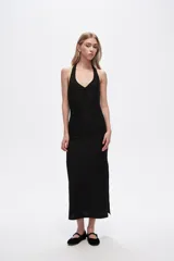 Vestido midi negro de poliéster, con breteles finos, escote halter y corte ajustado al cuerpo.