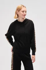 Buzo negro con capucha y cordón ajustable, de manga larga con detalle de franja con estampado animal print en los brazos.