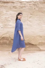 Vestido camisero azul de largo midi, con cuello mao con volados y mangas 3/4. Tiene cierre frontal con botones y un bolsillo de crochet aplicado.