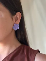 Aros con forma de flor color lila con brillo.