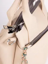Cartera de símil cuero color beige, con dos asas y correa desmontable, y bolsillo externo con detalle de cuerda.