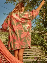 Vestido camisero de lino con estampado de palmeras en tonos rosados y verdes.