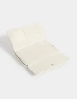 Billetera de cuerina estampada con cierre circundante y puller de material principal. Solapa con broche con botón para cerrado.