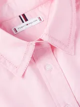 Vestido camisero Tommy Hilfiger color rosa, de corte oversize y largo hasta la rodilla. Confeccionado en algodón orgánico, con cuello inglés, cierre de botones, puños con botón y logo bordado en el puño.