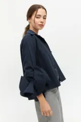 Camisa negra con cuello clásico y mangas largas con detalle de volados en los puños.