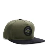 Gorro KristoBelga con visera plana, color verde militar con visera negra y parche redondo con logo de la marca en el frente.