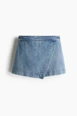 Short pollera de denim celeste, con frente cruzado y cierre oculto en la parte de atrás.