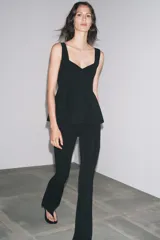 Top blanco de tejido elástico, con escote redondo, tirantes anchos y bajo peplum.