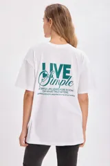 Remera blanca de corte amplio con estampa en la espalda con la frase 'Live Simple'.