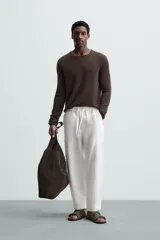Pantalón negro de lino, corte recto y relaxed fit, con cintura elástica ajustable con cordón, bolsillos laterales y traseros.