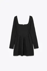 Vestido corto negro de manga larga con escote cuadrado y textura en relieve.