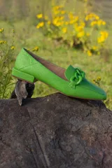 Mocasines fucsia con estampado de piel de serpiente y detalle de cadena plástica en el empeine.