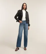 Camisa blanca de tricolina con cuello padre, abotonada al frente con detalle ondulado y mangas largas.