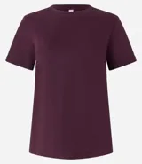 Remera tipo t-shirt de algodón, color beige claro, con cuello redondo y mangas cortas dobladas.