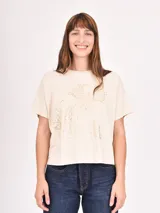 Remera blanca de corte recto con estampado de flores rojas y texto azul "PROFUMO DI FIORI".