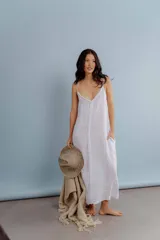 Vestido largo de lino color blanco, con breteles finos y detalle de costura o aplique vertical en el centro del frente.