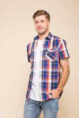 Camisa de manga corta con estampado a cuadros en tonos azul, rojo y blanco. Cierre con botones y tela ligera.