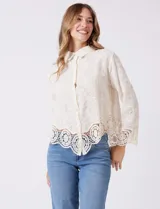 Camisa de algodón color naranja, con bordado suizo y encaje calado. Tiene cuello con solapa, botones frontales, mangas largas con terminación de encaje y ruedo asimétrico con galón de encaje.