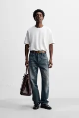 Pantalón de jean azul con efecto lavado, corte recto y largo al tobillo.