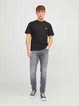 Jean de hombre gris con corte slim fit, cinco bolsillos y cierre con botón.