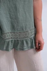 Musculosa verde seco de lino italiano, corte amplio y terminaciones delicadas con encaje en el ruedo.