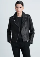 Chaqueta de cuero ovino negra, estilo biker, con cuello con solapa, cierre frontal asimétrico con cremallera, mangas largas con cremallera en los puños, dos bolsillos laterales con cremallera y forro interior de poliéster.