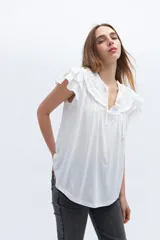 Blusa blanca de lyocell y algodón, con escote fruncido con volados y lazos.