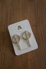 Aros colgantes con forma geométrica, con peltre color beige y apliques de strass.