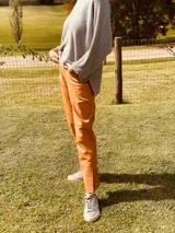 Pantalón de cuero ovino color camel, corte mom fit con tiro semi alto y tajos inferiores.