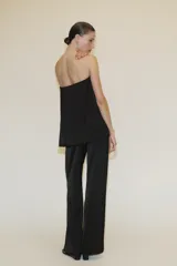 Top bandeau negro de tejido satinado con escote recto y hombros descubiertos. Tiene bandeau interior y cierre lateral con cremallera oculta.