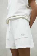 Shorts blancos de algodón orgánico y reciclado, con cintura elástica ajustable y bolsillos laterales.